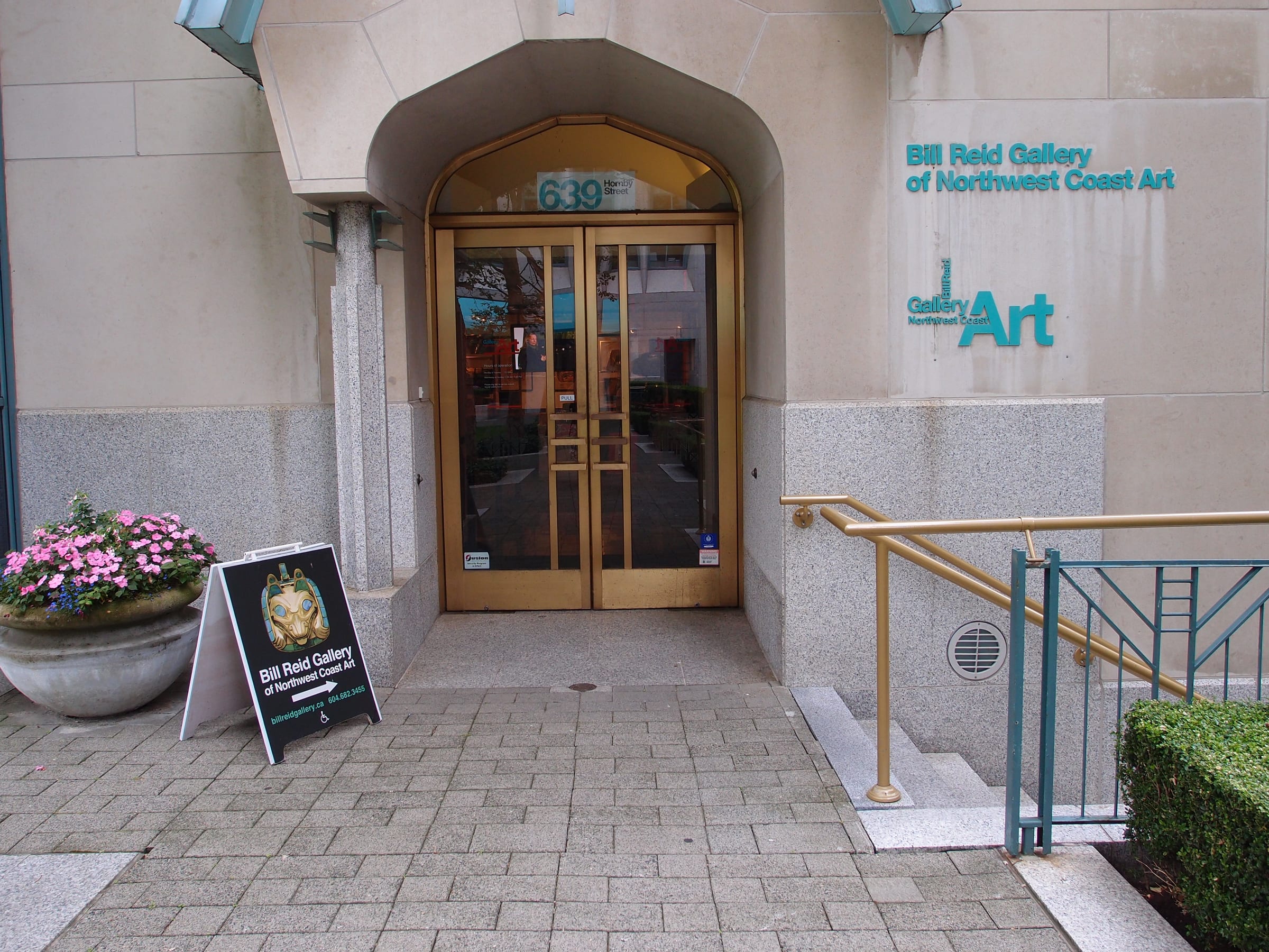 Brass doors and teal lettering mark the Hornby Street entrance of the Bill Reid Gallery of Northwest Coast Art.